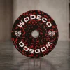 25 kg weight plate with a black and red speckled design, standing upright on a gym floor (brand 'WODECO' visible).
