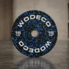 Black 15 kg weight plate with blue speckled pattern and white lettering, standing on a gym floor.