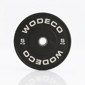 Black 5 kg weight plate with 'WODECO' lettering on white background, reflective surface visible underneath